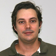 Prof. Thiago Faggion de Pádua Foto de Thiago Faggion de Pádua, um homem de pele branca, com cabelos castanhos lisos e curtos. Olhos castanho-escuros Ele usa uma camisa polo verde militar com a gola aberta e tem leve sorriso nos lábios.