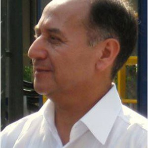 Foto de perfil de Ernesto Antonio Urquieta Gonzalez, um homem de pele branca, levemente calvo e com cabelos castanhos grisalhos nas laterais. Ele usa uma camisa branca.