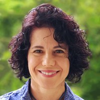 henriette+cordeiro+azeredo.jpg Foto de Henriette Monteiro Cordeiro de Azeredo, uma mulher de pele parda, com cabelos ondulados na altura das orelhas. Seus olhos são castanhos e seus cabelos tem cor castanha levemente avermelhada com a luz do sol. Ela usa camisa azul claro e sorri.