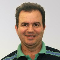 João+Batista+Oliveira+dos+Santos.jpg Foto de João Batista Oliveira dos Santos, um homem de pele branca, com cabelos curtos mais volumosos na parte de cima. Seus cabelos e olhos são castanhos. Ele usa uma camisa polo com gola verde e listras pretas, verdes e azuis e sorri.